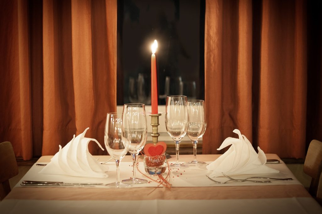 vinske čaše i svijeća na stolu za dvoje