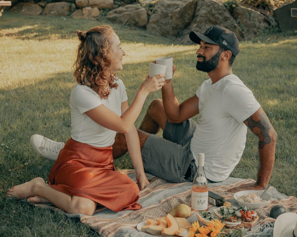 žena i muškarac nazdravljaju na pikniku u prirodi
